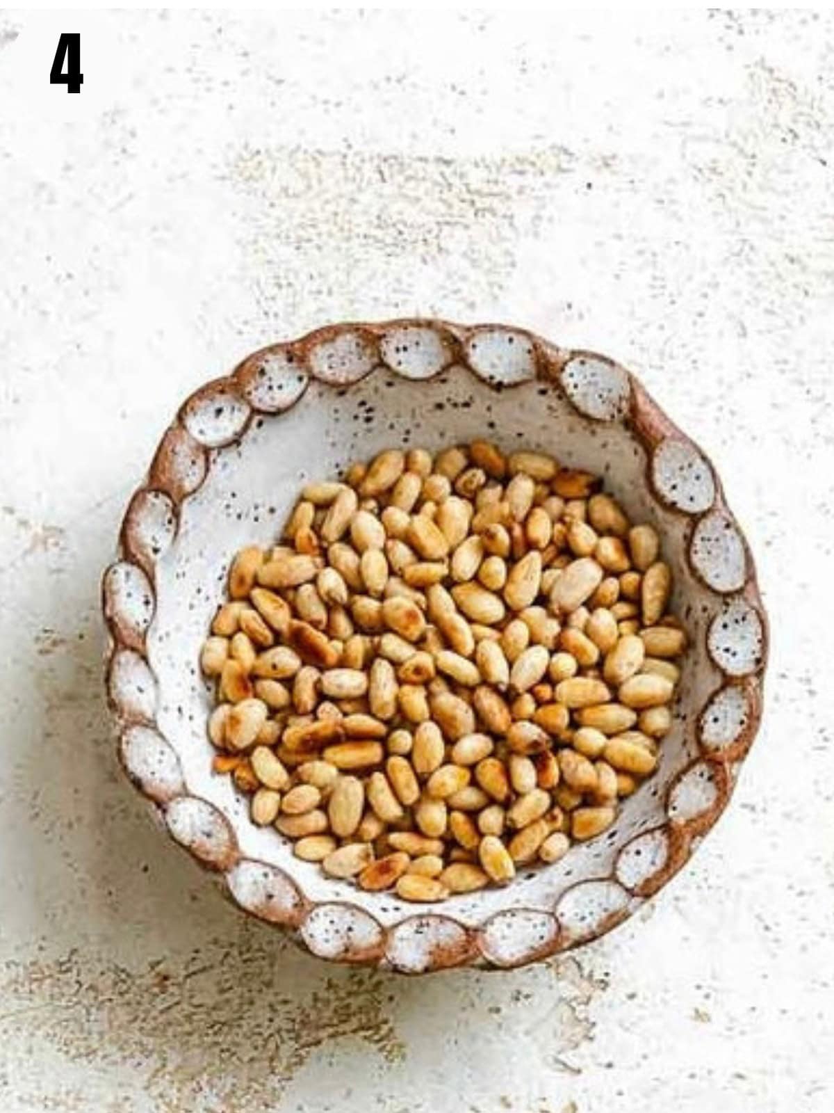 Toasted pine nuts in a bowl.