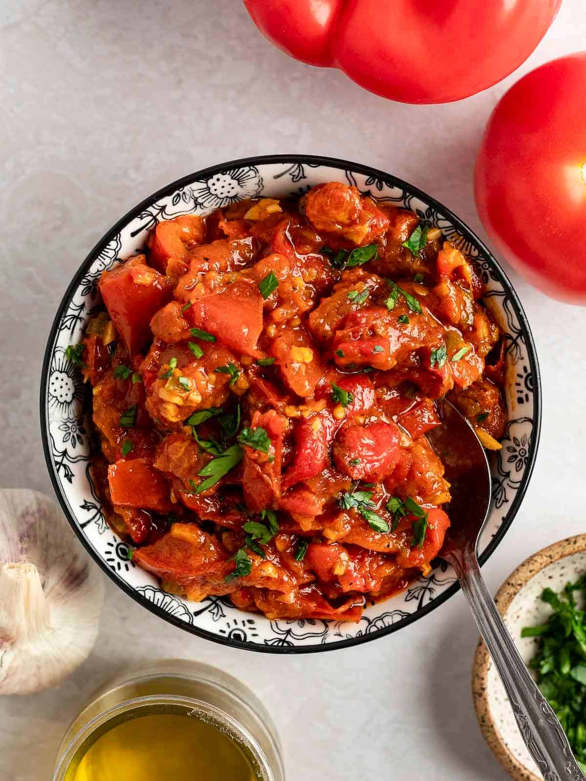 Matbucha in a bowl with a spoon.