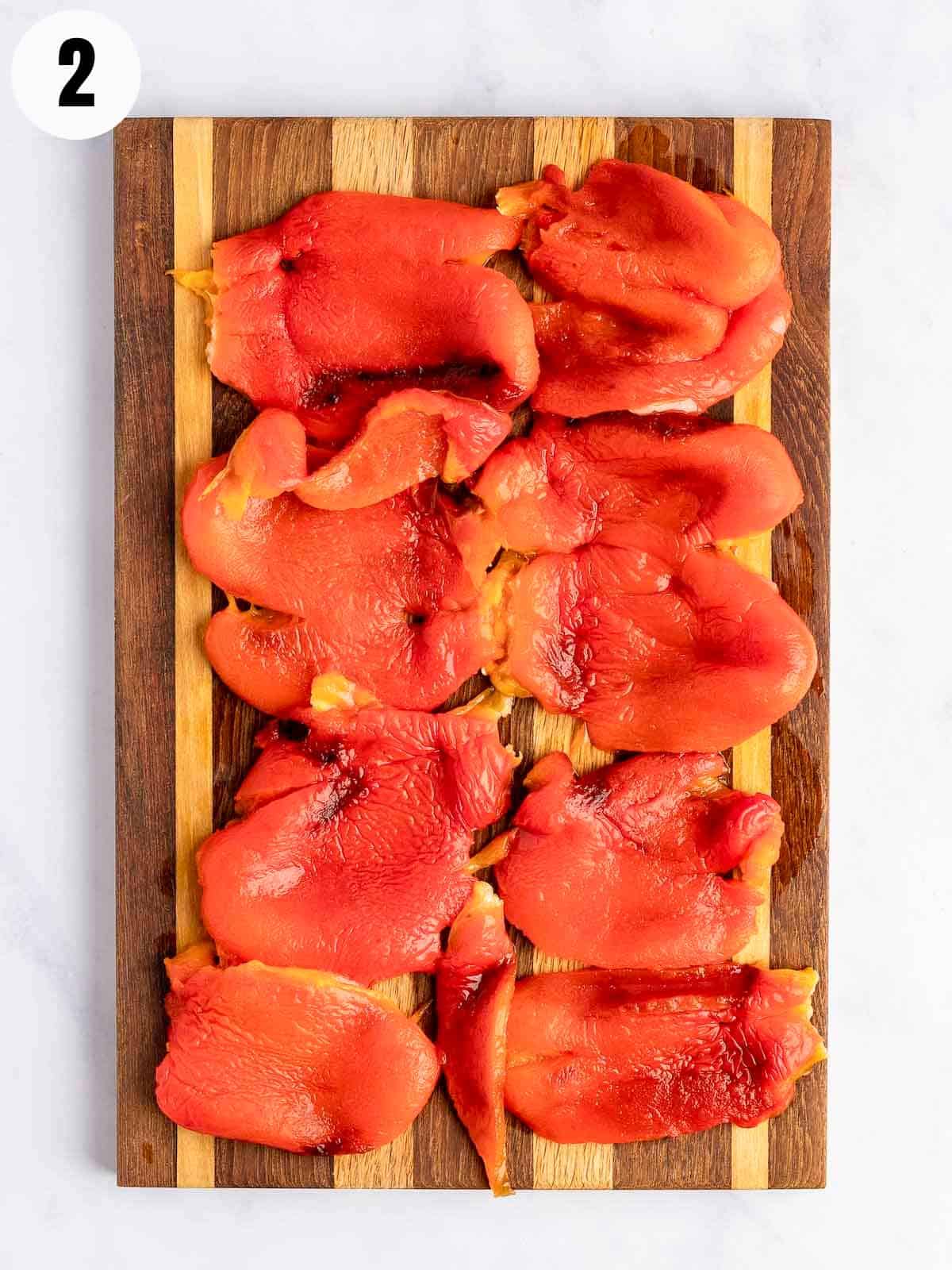 Peeled roasted peppers on a cutting board.