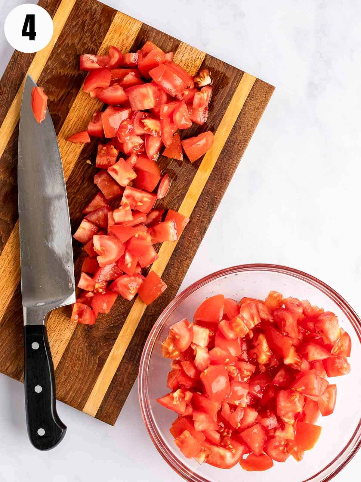 Transferring chopped tomatoes to a glass bowl.